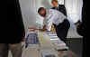 Barack Obama signs posters and campaign materials backstage on October 26, 2008 at a Reno Nevada campaign rally.