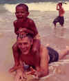 Barack Obama plays with his maternal grandfather (Dunham) in the Waikiki beach surf in Honolulu, Hawaii. Barck Obama family photo circa 1960s.