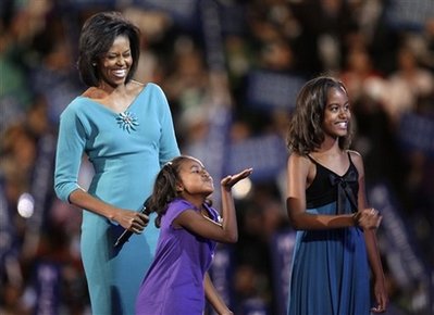 Watch the Special Video Biography of Michelle Obama Shown at the DNC Convention in August 2008. Photo: Sasha Obama at DNC in Denver blows a kiss to her dad on satellite TV.