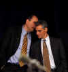 David Axelrod whispers to Rahm Emanuel at Barack Obama's December 19th press conference in Chicago.