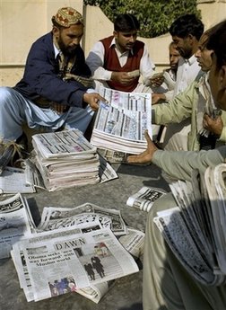 Newspaper runners get ready in Islamabad, India. Barack Obama's presidential inauguration dominates international newsstands.
