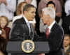 President Barack Obama is welcomed to the stage of the Harborside Event Center in Fort Meyers, Florida by Florida Governor Charlie Crist (right) on February 10, 2009. President Obama spoke to the crowd then answered questions.
