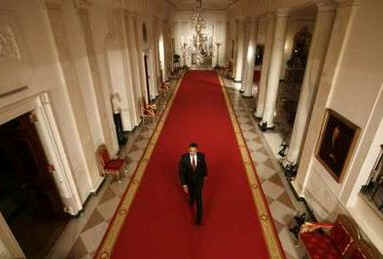 President Barack Obama walks down the Cross Hall of the White House to hold his first news conference as President in the East Room of the White House. The questions centered mostly on the President's economic stimulus package and the urgency of passing the financial bill.