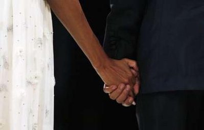 President Barack Obama and First Lady Michelle Obama hold hands at the Southern Regional Inaugural Ball at the National Guard Armory.