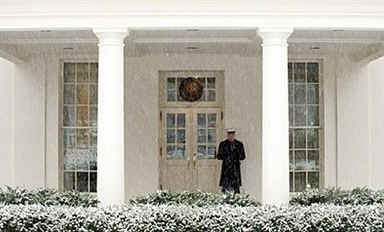 A US Marine stands guard at the West Wing of the White House as snow falls in Washington on January 27, 2009.