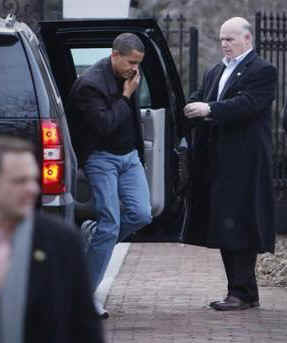 President Barack Obama arrives at a friend's house in Chicago while on his BlackBerry as he exits his motorcade SUV.