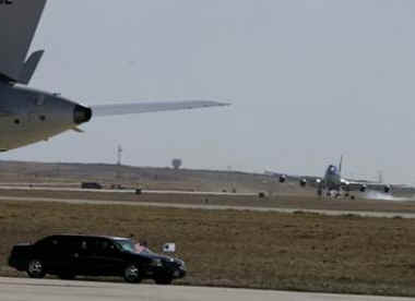 Air Force One with President Obama aboard lands as Air Force Two with Vice President Joe Biden sits on the tarmac near the presidential limo.