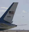 Air Force One with President Obama aboard lands as Air Force Two with Vice President Joe Biden sits on the tarmac.