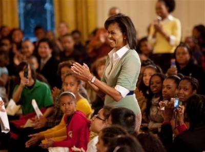 Michelle, Sasha, and Malia Obama watch the special performance of school children in the East Room of the White House. First Lady Michelle Obama spoke later to the students and pointed out a few historic White House facts.