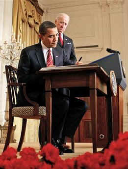 President Barack Obama with Vice President Joseph Biden at his side, signs several executive orders in the East Room of the White House on January 30, 2009. One of the executive orders was named the Middle Class Working Families Task Force.