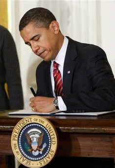 President Barack Obama with Vice President Joseph Biden at his side, signs several executive orders in the East Room of the White House on January 30, 2009. One of the executive orders was named the Middle Class Working Families Task Force.