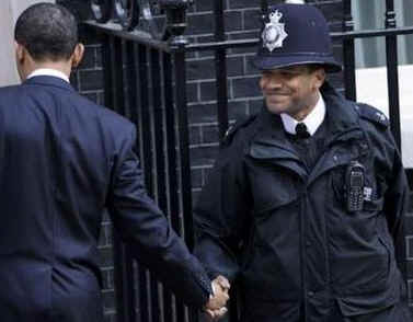 President Obama shakes the hand of a London police officer as he returns to the Downing Street residence.