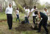 President Barack Obama and First Lady Michelle Obama plant trees with volunteers.