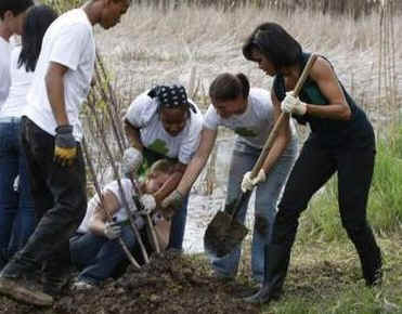 President Barack Obama and First Lady Michelle Obama plant trees with volunteers.