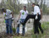 President Barack Obama gets muddy shoes planting trees with volunteers at the Kenilworth Aquatic Gardens.