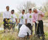 President Barack Obama and former President Bill Clinton plant trees with volunteers.