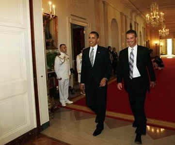 Gators Head Coach Urban Meyer walks into East Room with President Obama. Obama meets with the NCAA National Football Champion Florida Gators in the East Room of the White House.