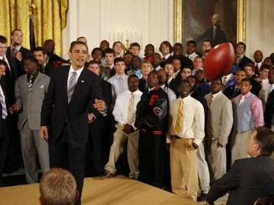 President Obama passes a football to his aide Reggie Love. President Barack Obama meets with the NCAA National Football Champion Florida Gators in the East Room of the White House.