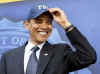 President Obama is introduced by FBI Director Robert Mueller who gives Obama an FBI cap.