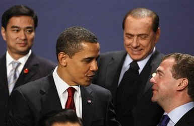 President Obama gestures during the G20 group photo with Russian President Medvedev and Italian Prime Minister Berlusconi.