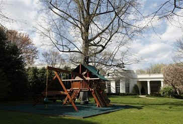 The Obama girls swing and play set with new padded mat made of recycled tires on the green grass of the White House Lawn.