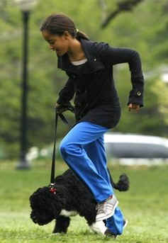 Malia Obama runs with Bo on the South Lawn of the White House on Bo's first day in his new home.