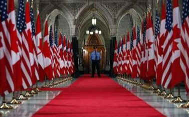 Canadian and American flags are alternately placed down the Hall of Honour in Parliament Hill on February 18, 2009.
