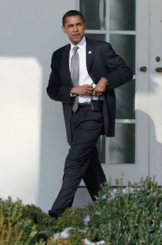 President Barack Obama holsters his Blackberry as he walks to the Oval Office on January 29, 2009.