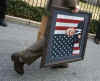 White House staffer waks away with portrait of President George W. Bush.