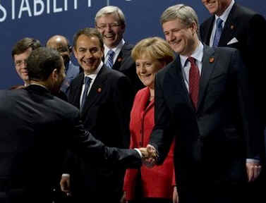 President Obama walked on the stage and walked directly to PM Harper to tease him about his absence from the original group photo.