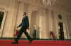 President Barack Obama walks down the Cross Hall of the White House to hold his first news conference as President in the East Room of the White House. The questions centered mostly on the President's economic stimulus package and the urgency of passing the financial bill.