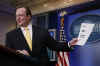 White House Press Secretary Robert Gibbs shows reporters document with the headlines of "Day 9" of Barack Obama's presidency.