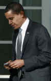 President Obama walks to the Oval Office holding his Blackberry which was recently altered for security reasons.