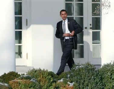 President Barack Obama holsters his Blackberry on his way to the Oval Office on the morning of January 29, 2009.