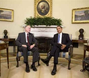 President Barack Obama talks to reporters in the Oval Office of the White House after discussions on his economic stimulus plan. Vermont Governor Jim Douglas sits with President Obama.