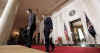 President Barack Obama leaves the Blue Room of the White House and speaks in the Grand Foyer with Treasury Secretary Timothy Geithner. Obama advises that any financial institution that requires a bailout will cap executive salaries at $500,000 per year.