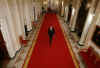 President Obama walks down the Cross Hall to media event. President Obama holds a one-hour live prime time news conference in the East Room of the White House on March 24, 2009.