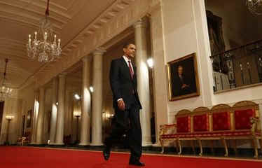 President Obama walks down the Cross Hall to media event. President Obama holds a one-hour live prime time news conference in the East Room of the White House on March 24, 2009.