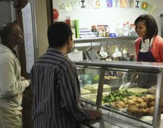 First Lady Michelle Obama speaks and serves meals at Miriam's Kitchen.