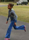 Sasha Obama departs Marine One covering her ears from the loud noise of the helicopter and runs across the South Lawn to the White House residence.