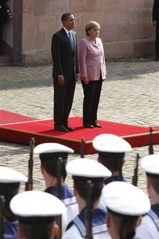President Barack Obama and German Chancellor Angela Merkel pause for the national anthems of the US and Germany.