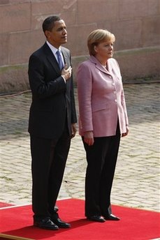 President Barack Obama and German Chancellor Angela Merkel pause for the national anthems of the US and Germany.