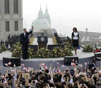 President Barack Obama is joined on the stage by First Lady Michelle Obama after Obama's speech. Saint Nicholas Church sets the backdrop for Obama's Prague speech. 
