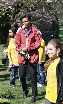 First Lady Michelle Obama tends to her White House Kitchen Garden with help from students of Bancroft Elementary School.