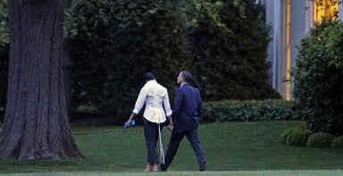 President Barack Obama and First Lady Michelle Obama return to the White House and walk across the South Lawn after a Saturday evening dinner.