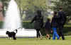 First Lady Michelle Obama walks with Bo on the South Lawn of the White House on Bo's first day in his new home.