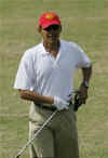 Obama re-holsters his Blackberry after it drops off his belt at a driving range in Hawaii on December 29, 2008.